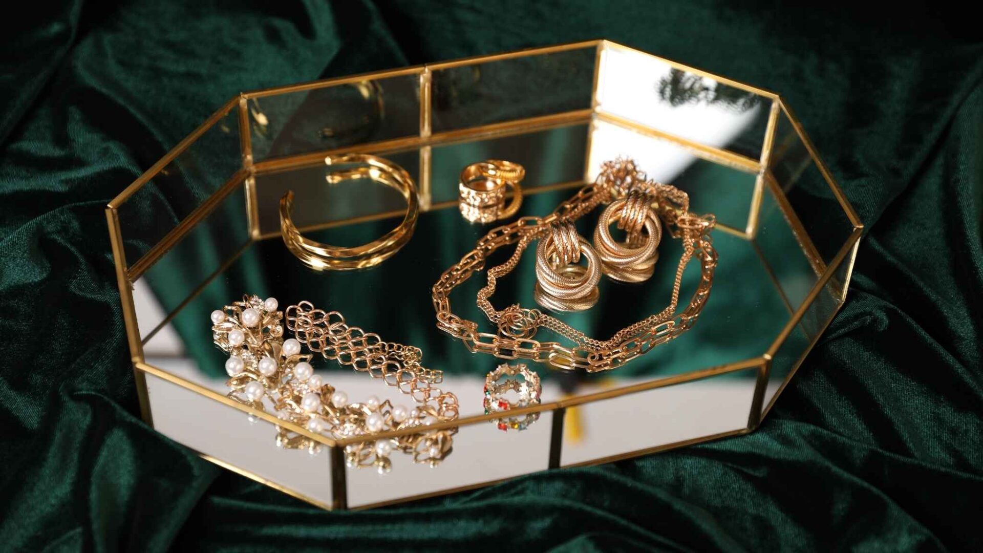 Joyas de oro elegantes como anillos, pulseras y collares sobre superficie de lujo, representación de sueños relacionados con riqueza y abundancia