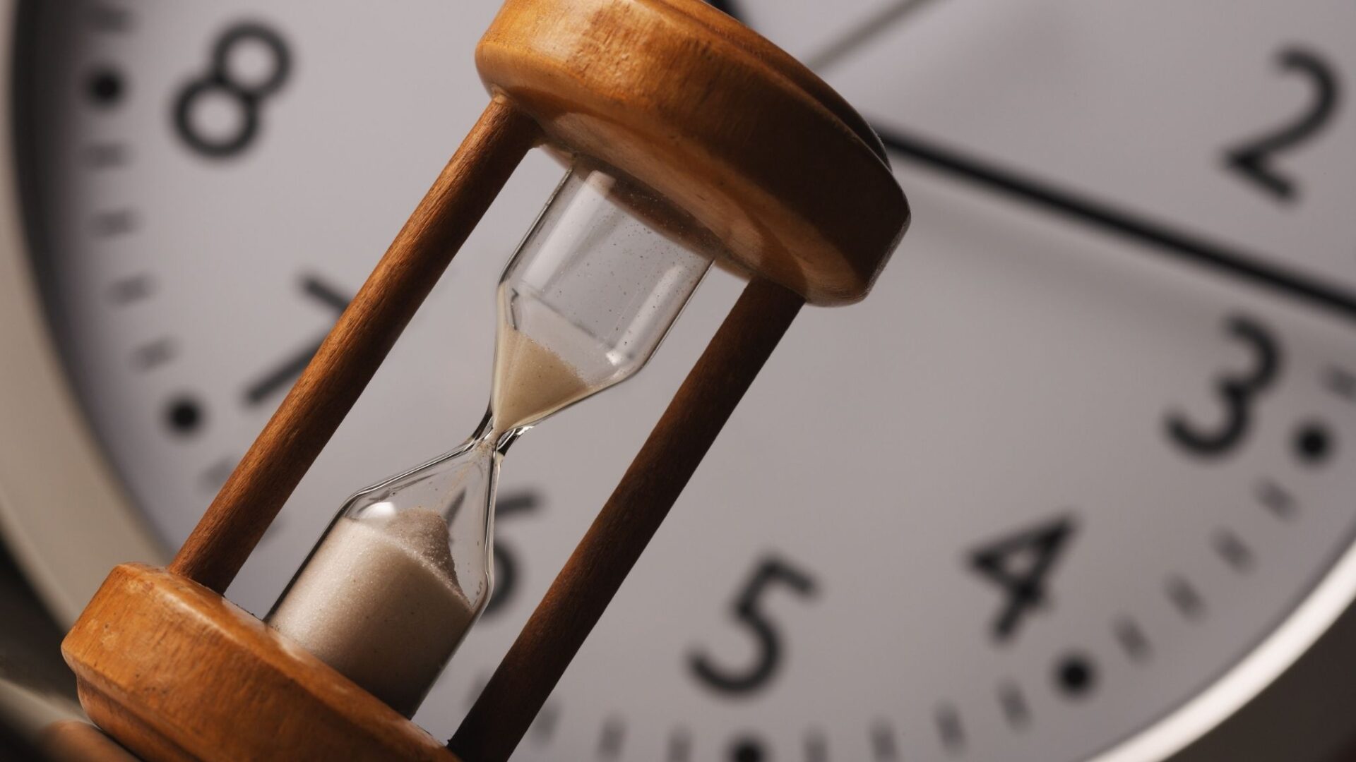 Reloj de arena frente a un reloj analógico simbolizando el paso del tiempo y la interpretación de soñar con un reloj