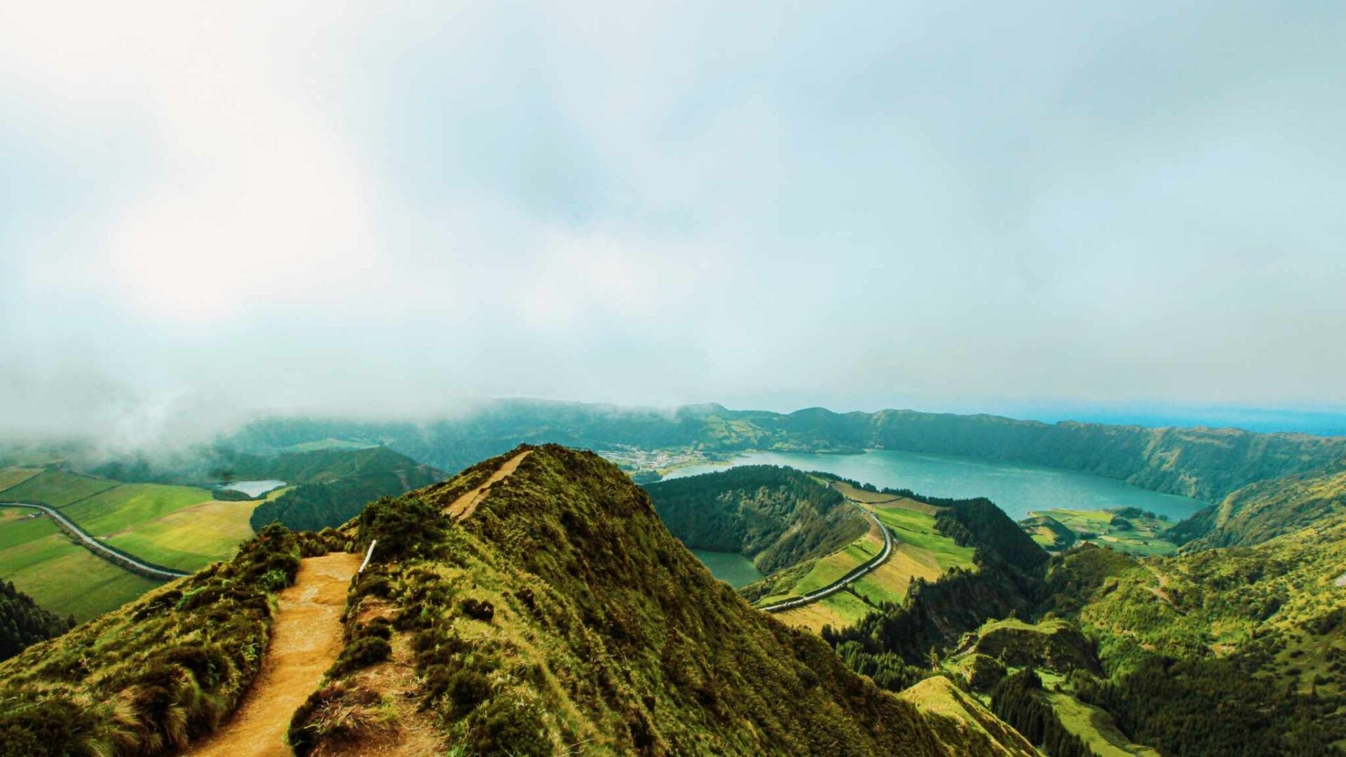 paisaje de montaña en sueño con camino elevado y lago que representa el significado y número asociado a soñar con montaña